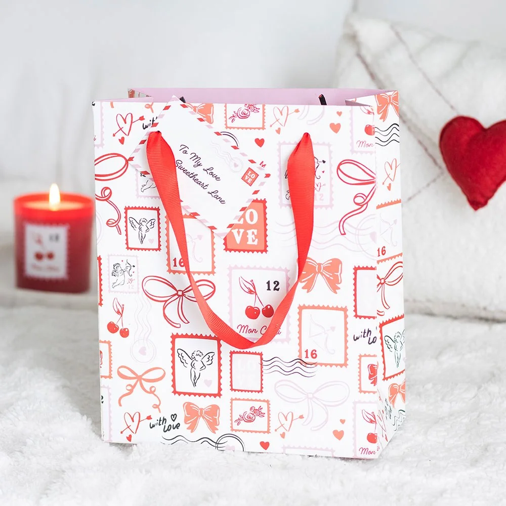 Valentine gift bag, 23 cm paper bag with playful postage stamp print featuring love letter motifs.