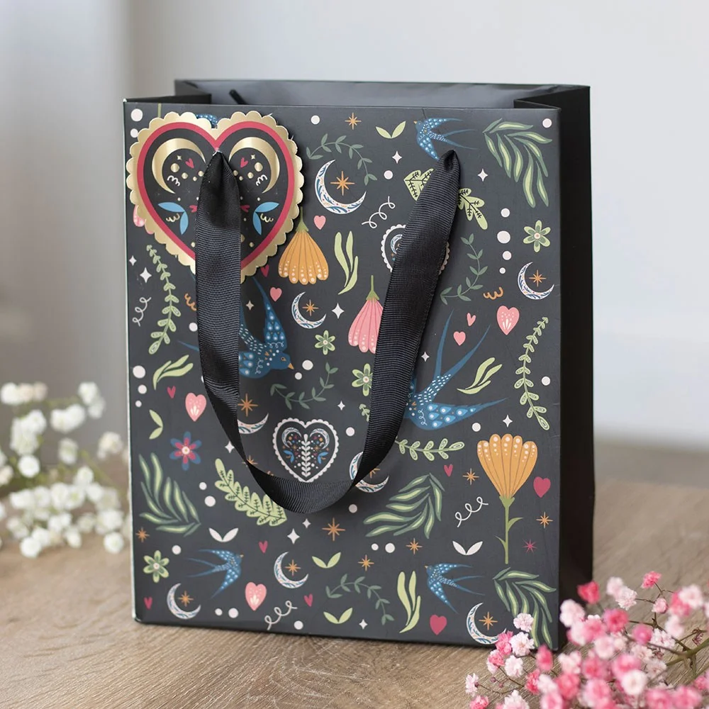 Medium paper gift bag with black background and bold Midnight Bloom floral print, suitable for gifting occasions