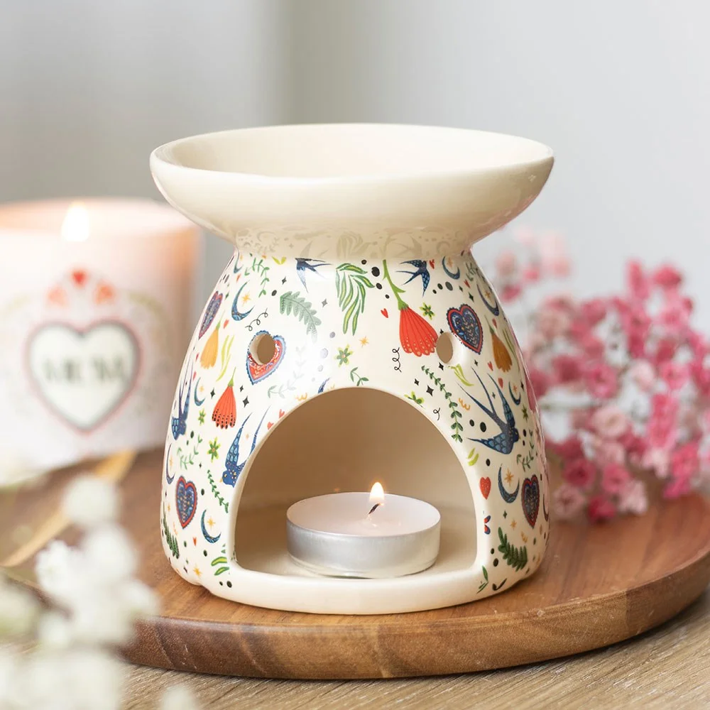 Cream ceramic oil burner with Midnight Bloom floral design, showing bowl for wax and tealight holder at the back