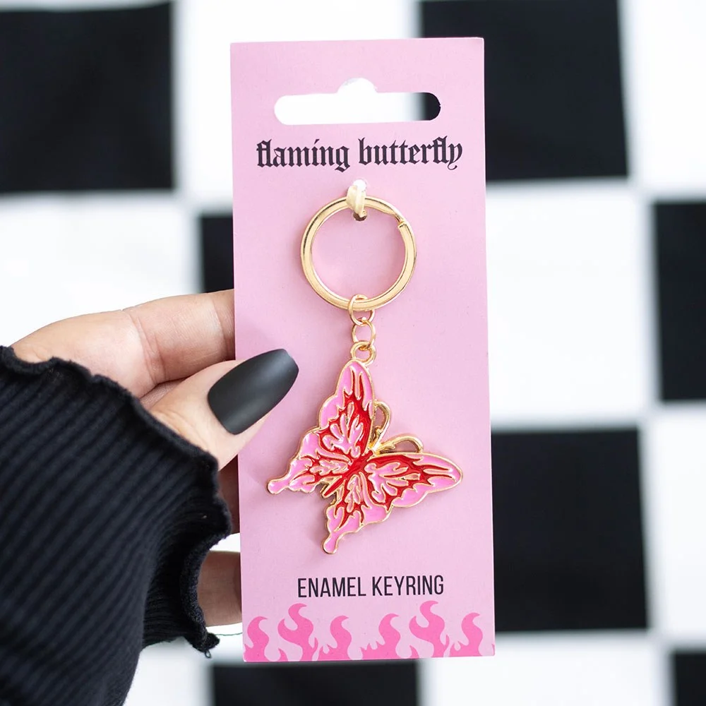 Pink and red flaming butterfly keyring with cybersigil design clipped to a silver keyring on a white background
