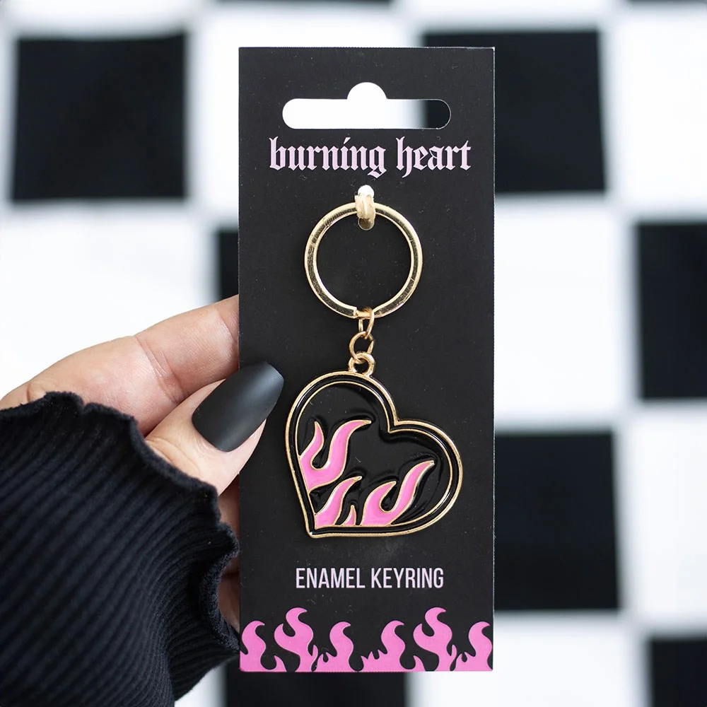 Flaming heart keyring with red heart and orange flames attached to a silver clip on a white background
