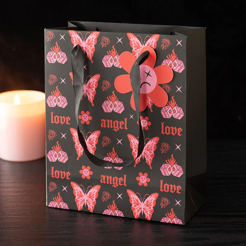 Medium flaming butterfly gift bag with cybersigil butterfly print and pop-punk motifs like angel, love, and flaming dice