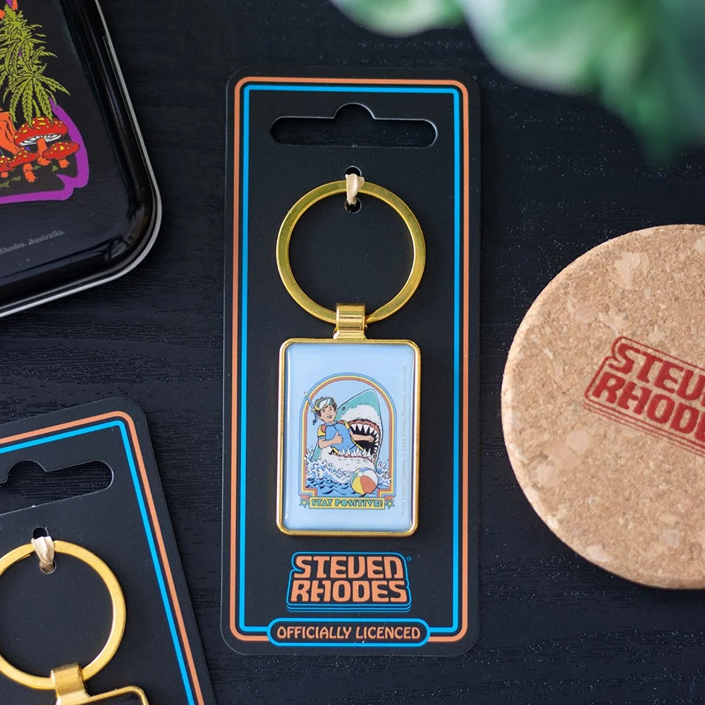 Stay Positive keyring showing a smiling snorkeller facing a shark attack, enamel design by Steven Rhodes
