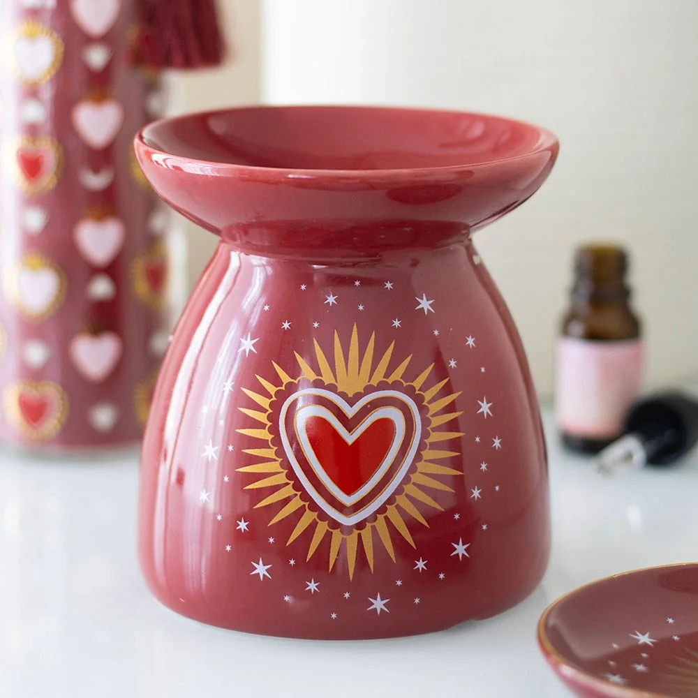 Elegant ceramic oil burner with radiant heart design, holding a tealight and bowl for fragrance oil.