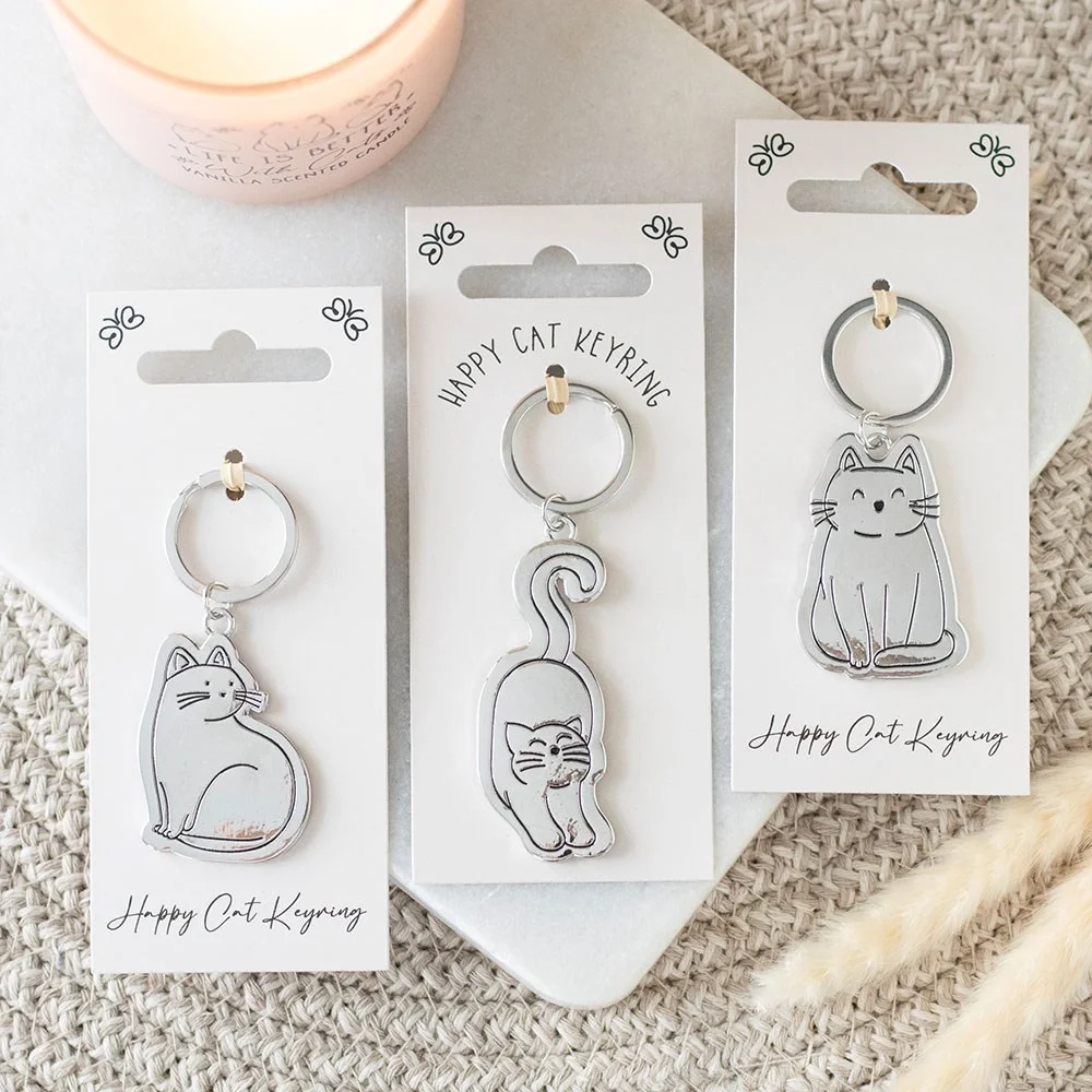 Set of 24 happy cat keyrings in various playful poses displayed on a matching MDF stand with metallic finish