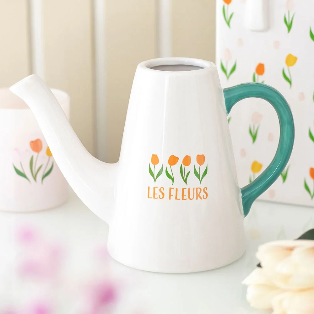 White ceramic watering can with "Les Fleurs" text and colorful tulip illustrations on the side
