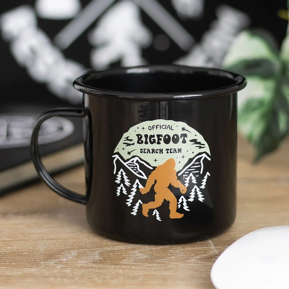 Bigfoot enamel mug with a black rim and handle, featuring a Bigfoot search team graphic and 450ml capacity.