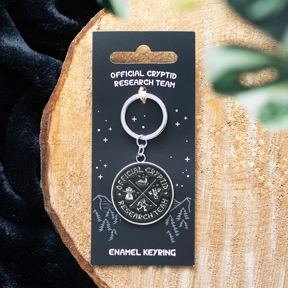 Cryptid Research Team enamel cryptid keyring with monster silhouette and text on white background
