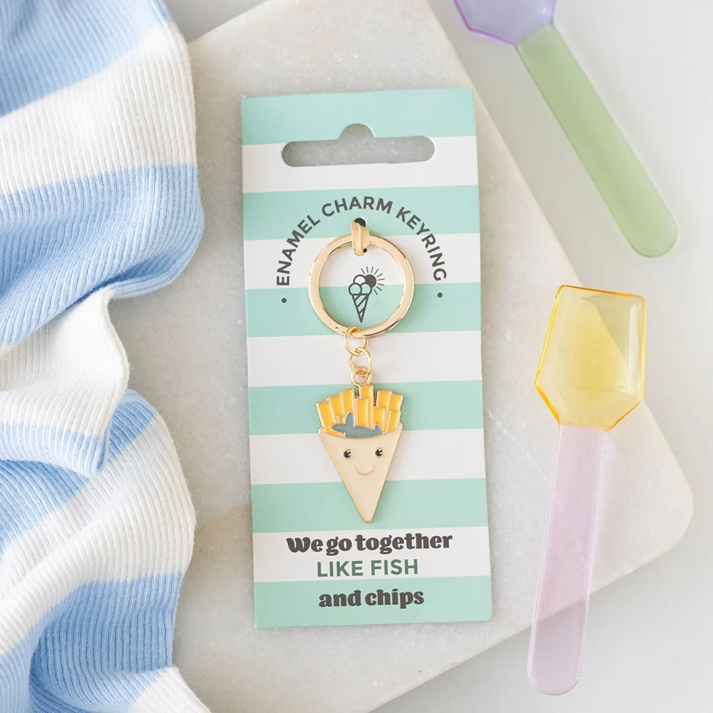 Enamel fish and chips keyring with a green fish and fries design, perfect seaside souvenir accessory.