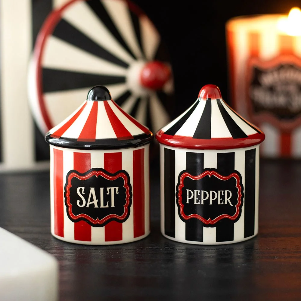 Ceramic salt and pepper shakers in bright red and black circus tent stripes, a festive duo for lively kitchens