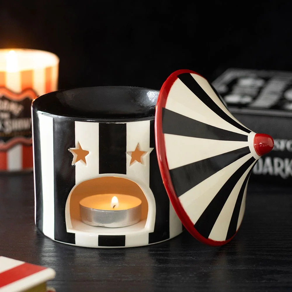 Black striped circus‑inspired ceramic oil burner with twisted tent shape, open lid and oil bowl