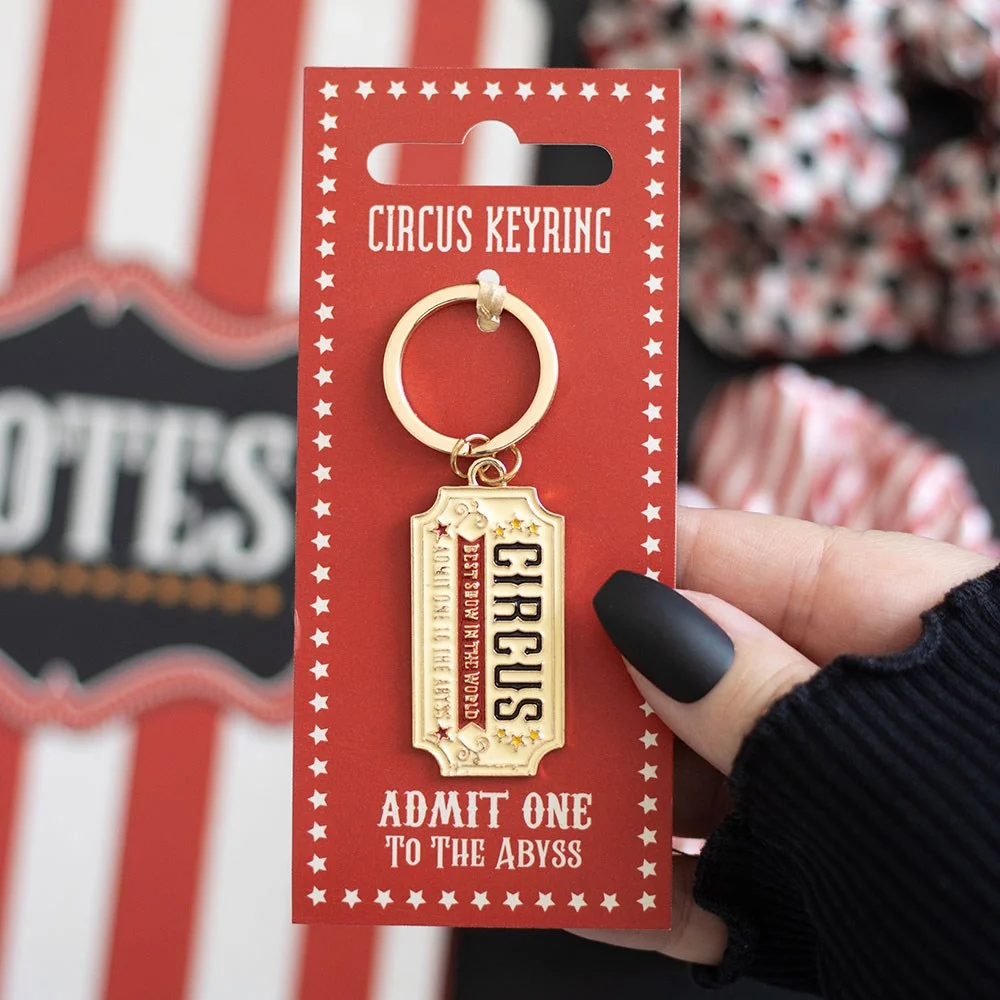 Circus ticket keyring styled like a vintage enamel ticket, with whimsical circus motifs and bold design