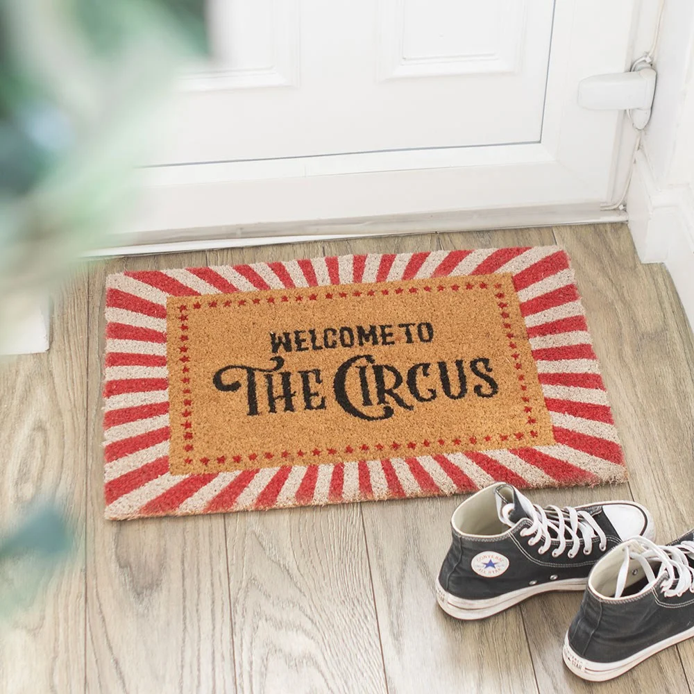Red and white striped circus welcome doormat with vintage-style lettering.