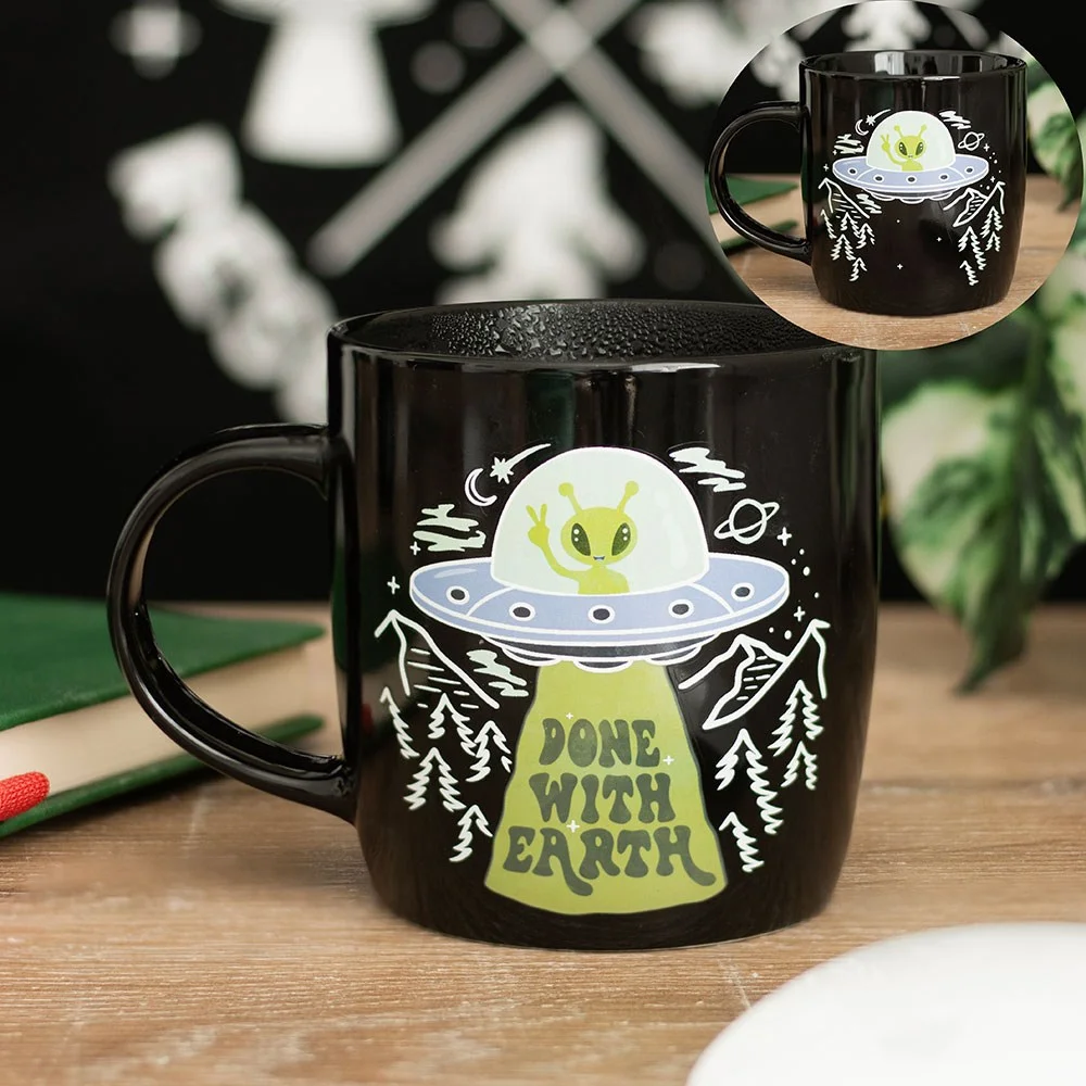 White heat change mug with green alien and "Done With Earth" text revealed when filled with hot liquid, 350ml capacity