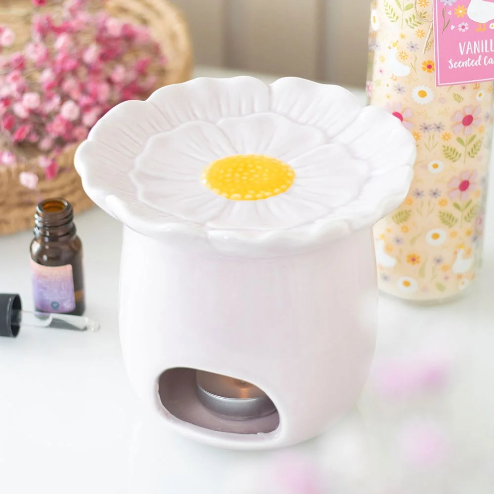 Ceramic pink daisy oil burner with a bowl for fragrance oil and space for a tealight candle at the back
