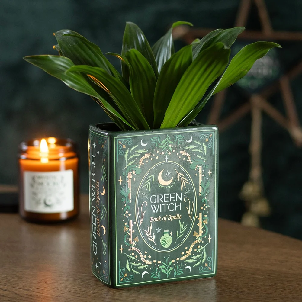 Ceramic green witch vase shaped like an ancient book with detailed mystical green artwork and flowers inside