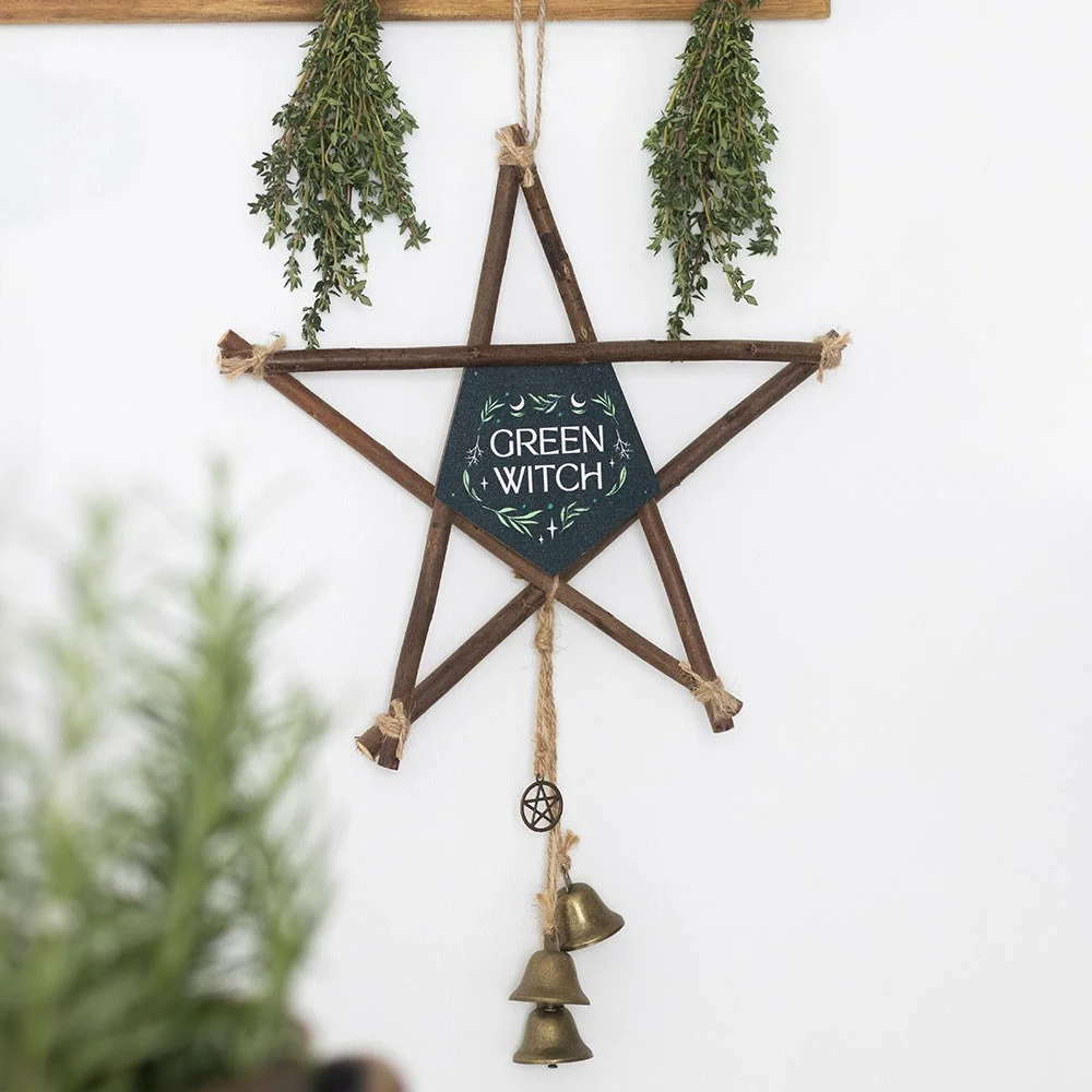 Willow pentagram decoration with central green witch symbol and three hanging brass bells on natural branches