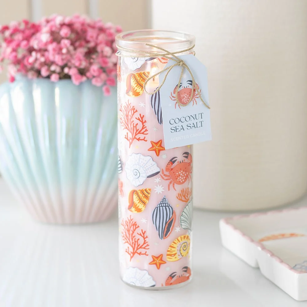 Tall glass coconut sea salt candle with pastel shell, crab, and starfish prints for coastal decor