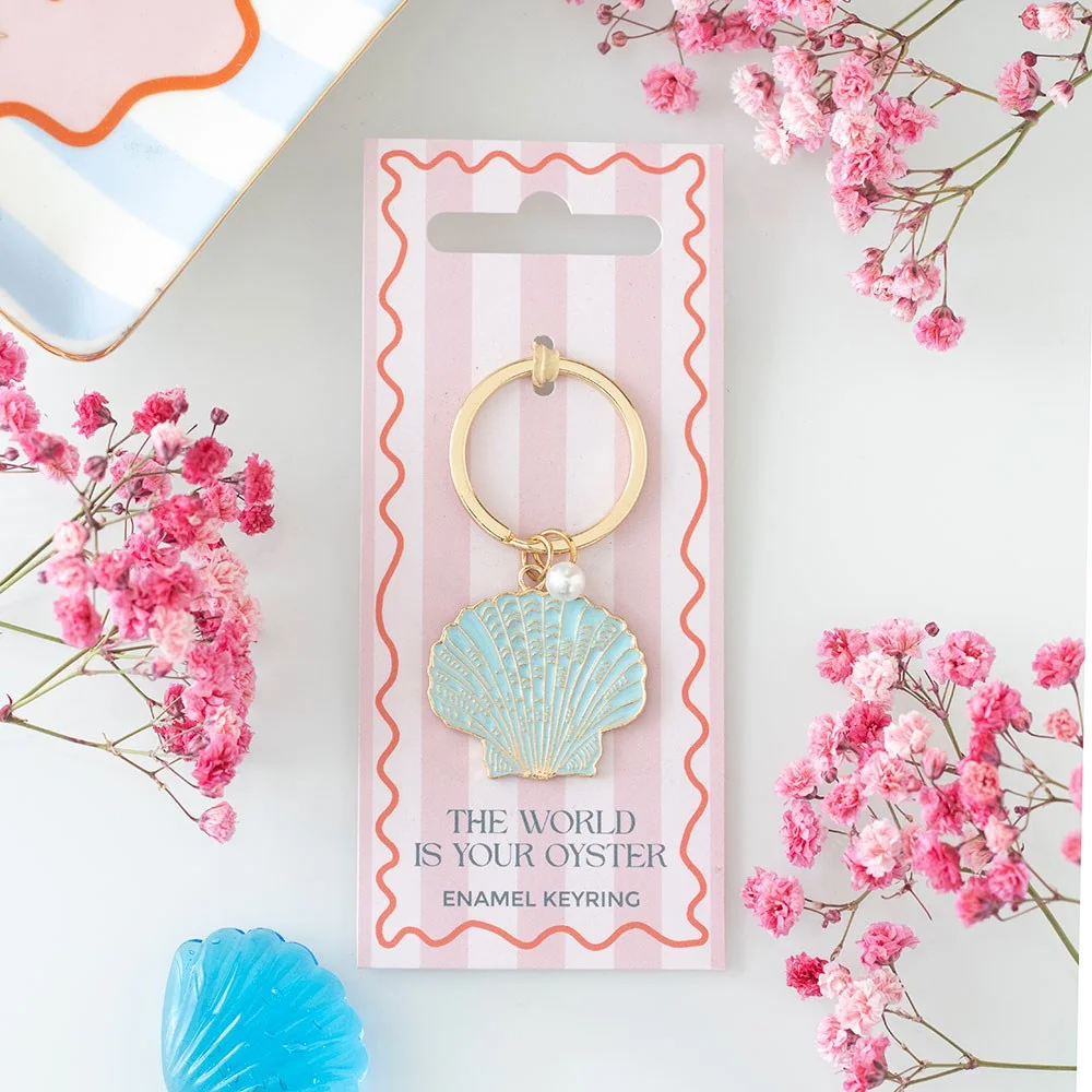 Pastel shell enamel keyring with phrase The world is your oyster on a silver ring accessory for keys