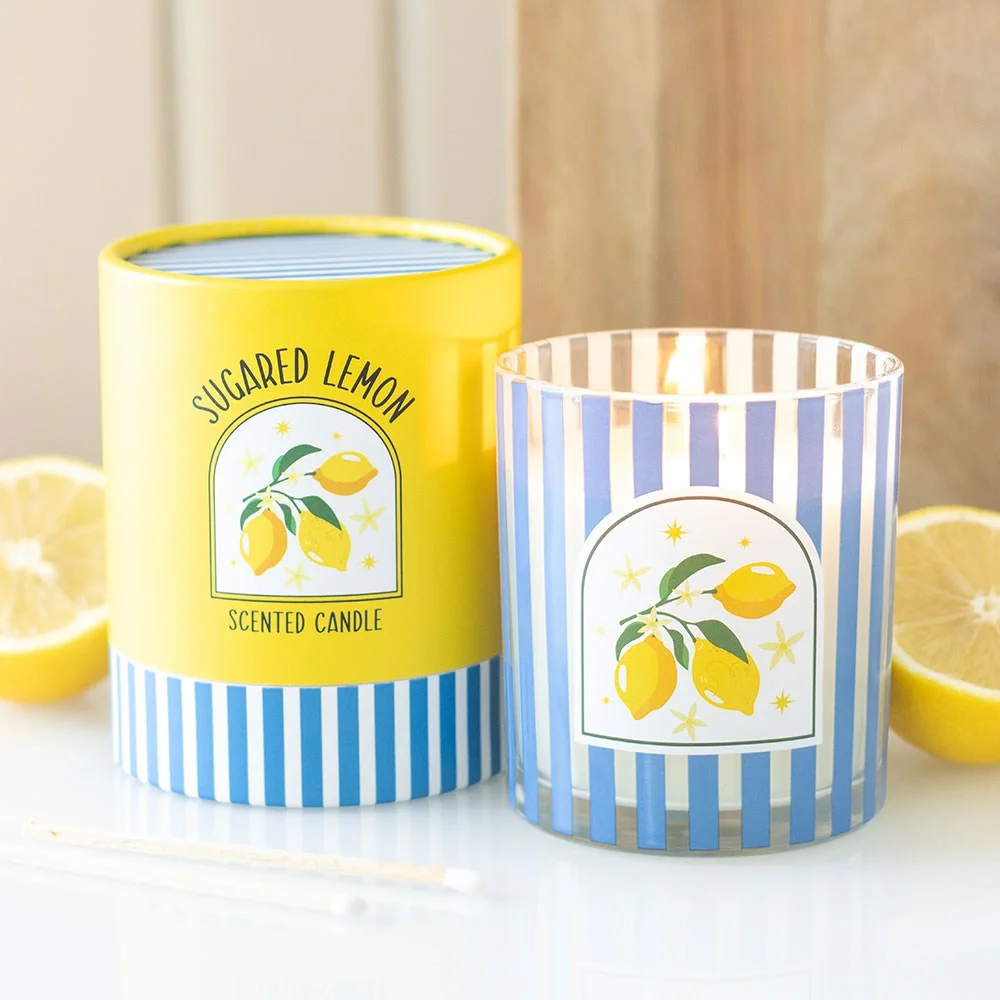 Striped blue glass jar holding a lemon scented candle made of paraffin wax, radiating citrusy aroma.