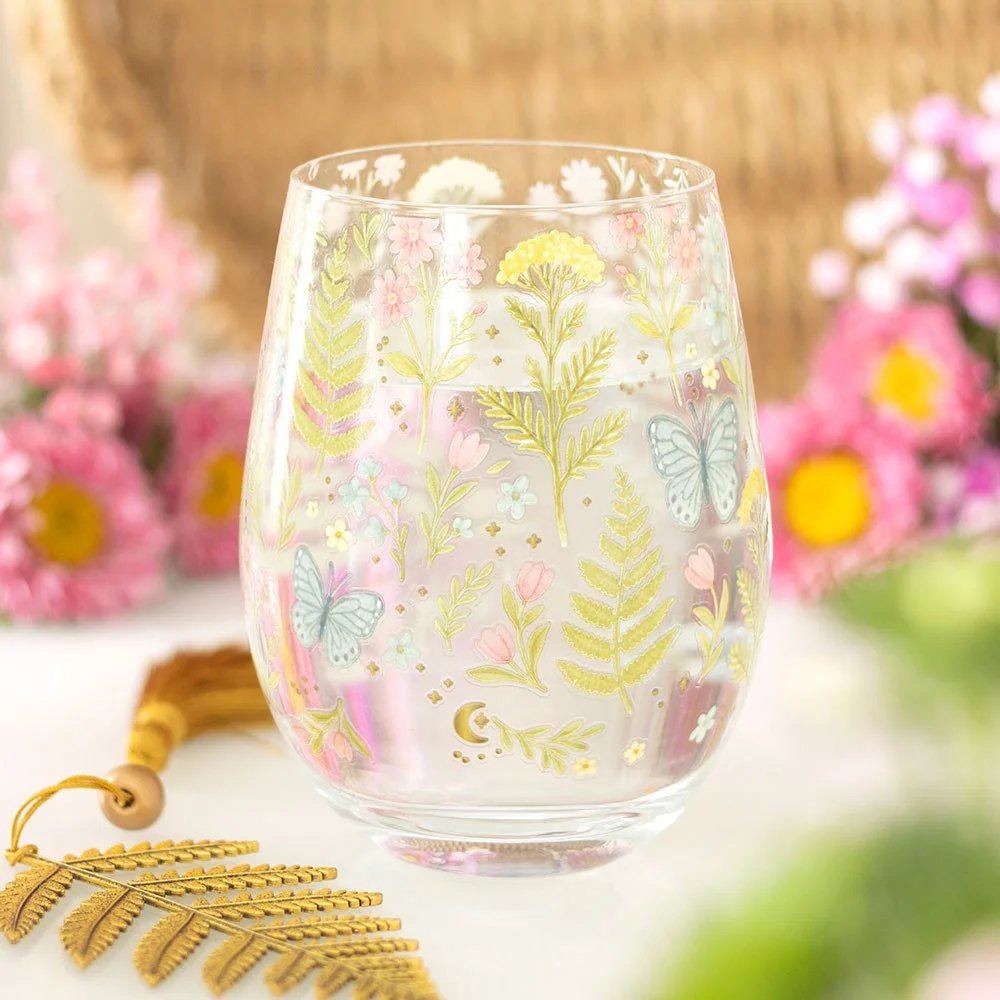 Clear stemless floral glass with soft pink and white flowers and a small butterfly design, 450ml capacity.