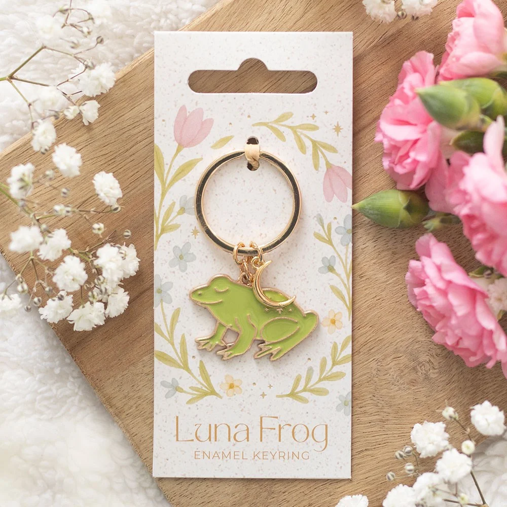 Cheerful enamel frog keyring with celestial details, bright green and gold, attached to a silver keyring loop
