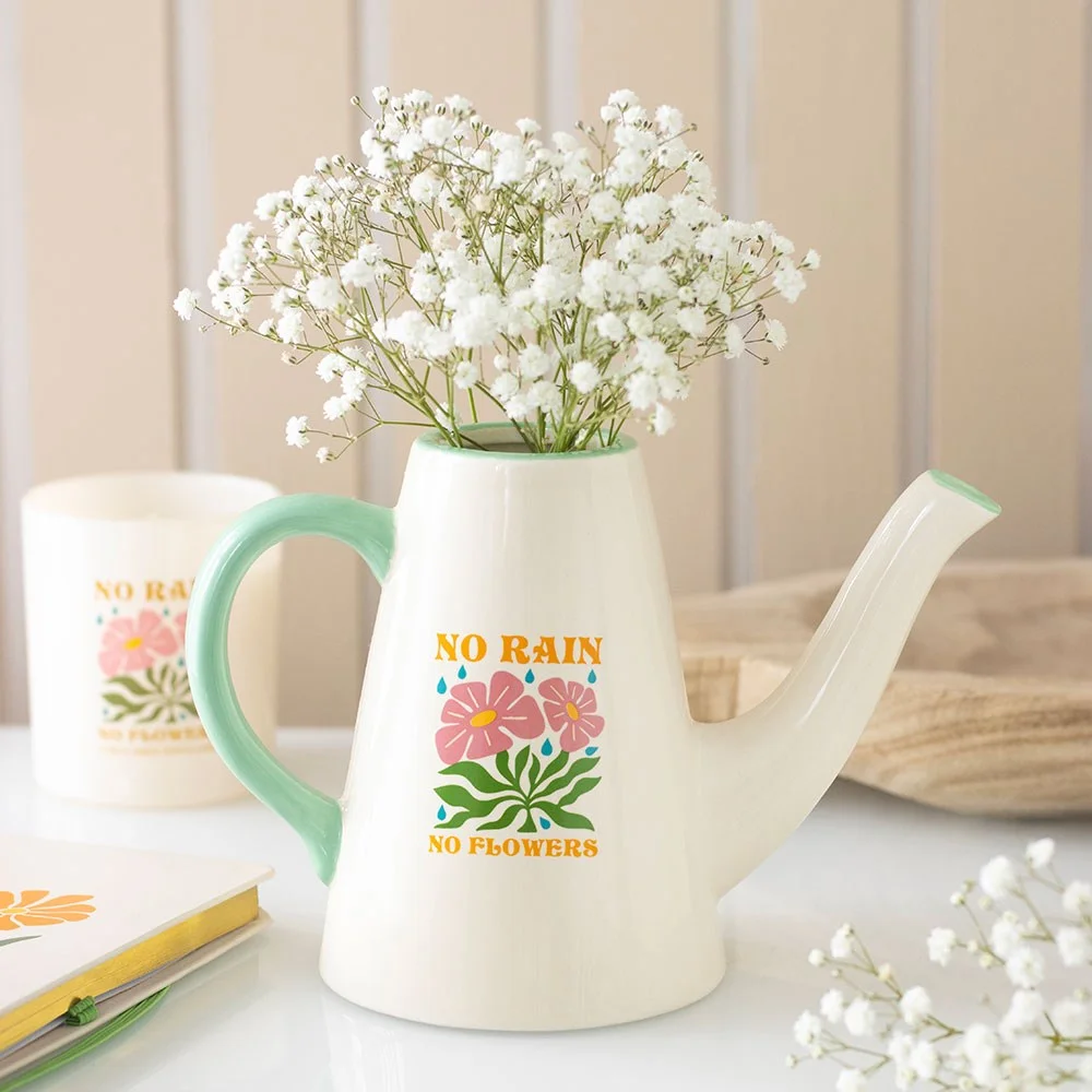 Ceramic watering can with colourful 'No Rain, No Flowers' design, 600ml capacity, perfect for houseplants or fresh blooms.
