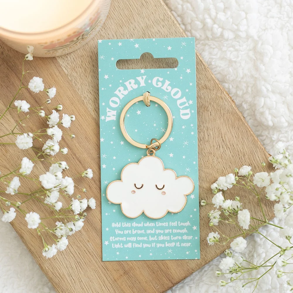 Cute enamel cloud keyring with soft pastel detail, hanging off a keychain, a pocket‑sized charm for holding worries