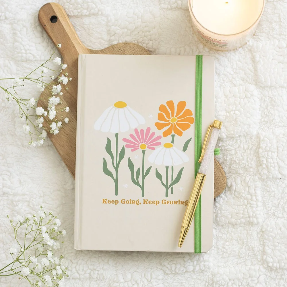 Mindfulness A5 notebook on a table with a rose quartz pen beside it, open to a page with daily prompts and reflection prompts