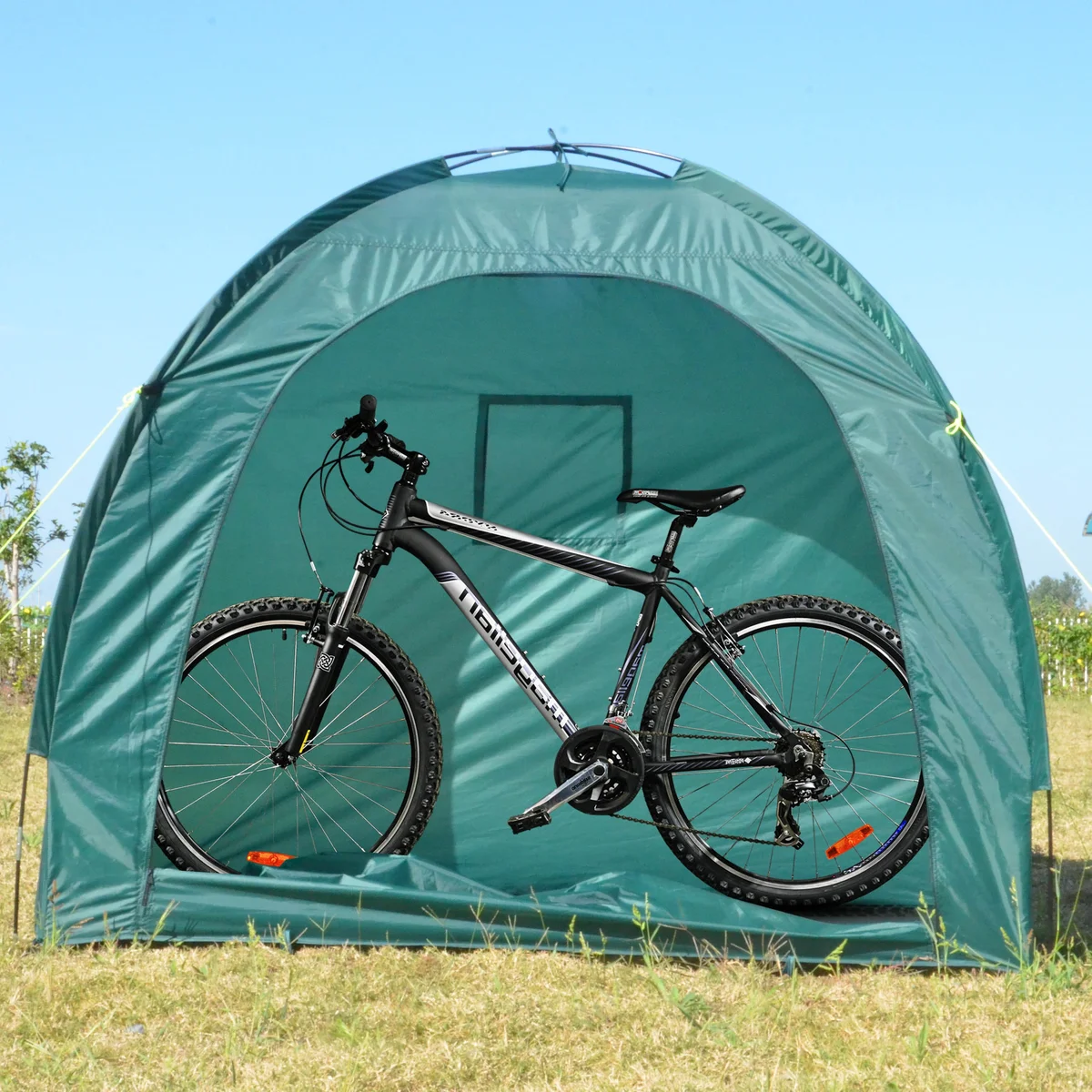 Green weatherproof garden tent with domed shape, fiberglass poles, and sewn-in groundsheet set up outdoors on grass