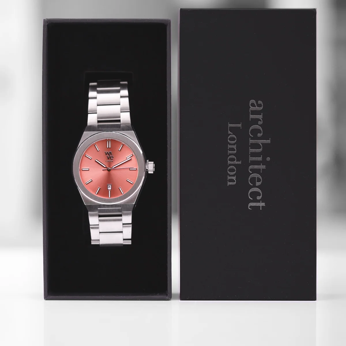 Wave by Architect watch in Peach Breeze with luminous dial watch, stainless steel band, and modern font engraving close-up view