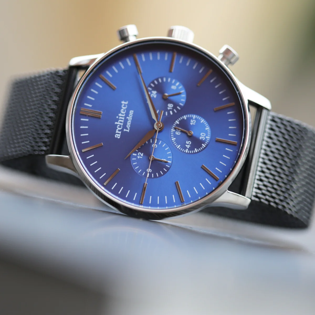 Men's motivator watch with deep-space blue dial, black Milanese mesh strap, and three chronograph subdials on stainless steel case
