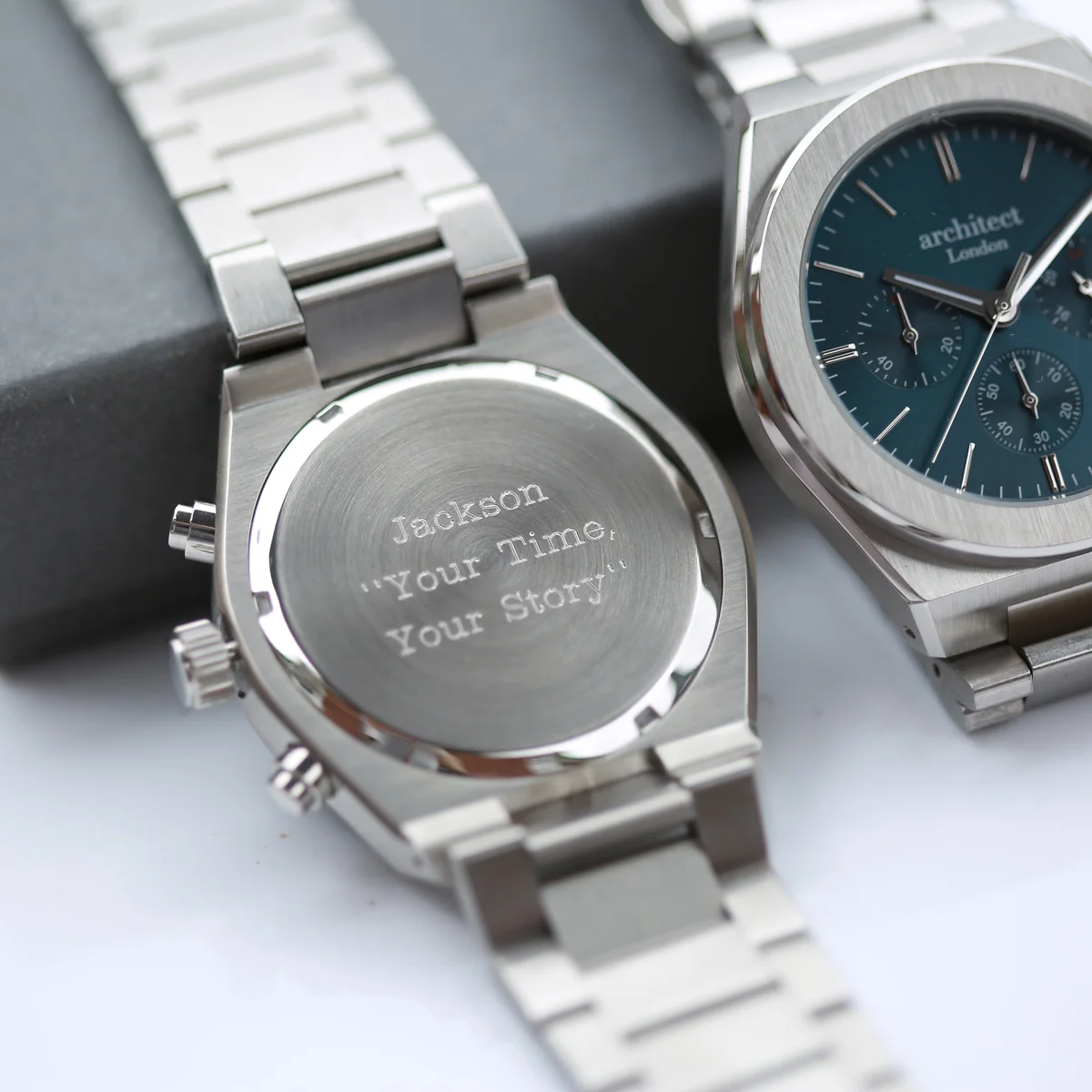 Engraved mens watch with deep blue dial, silver stainless steel band, three chronograph subdials, and modern font engraving area