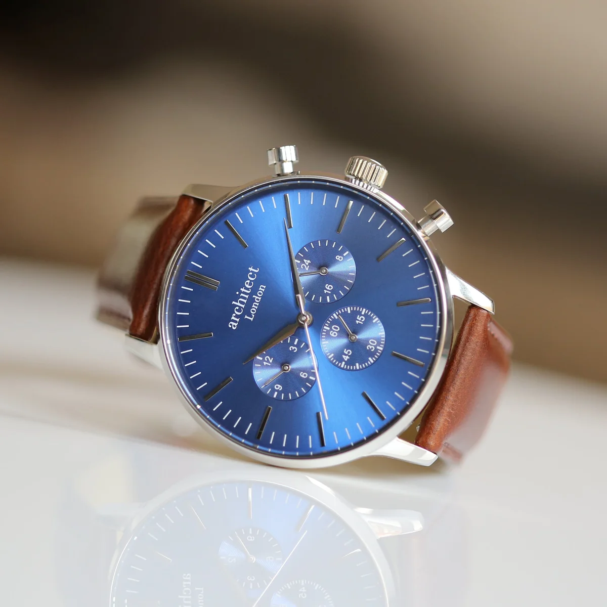 Men’s blue motivator watch with walnut strap and modern font engraving on the dial, showing contactless payment feature