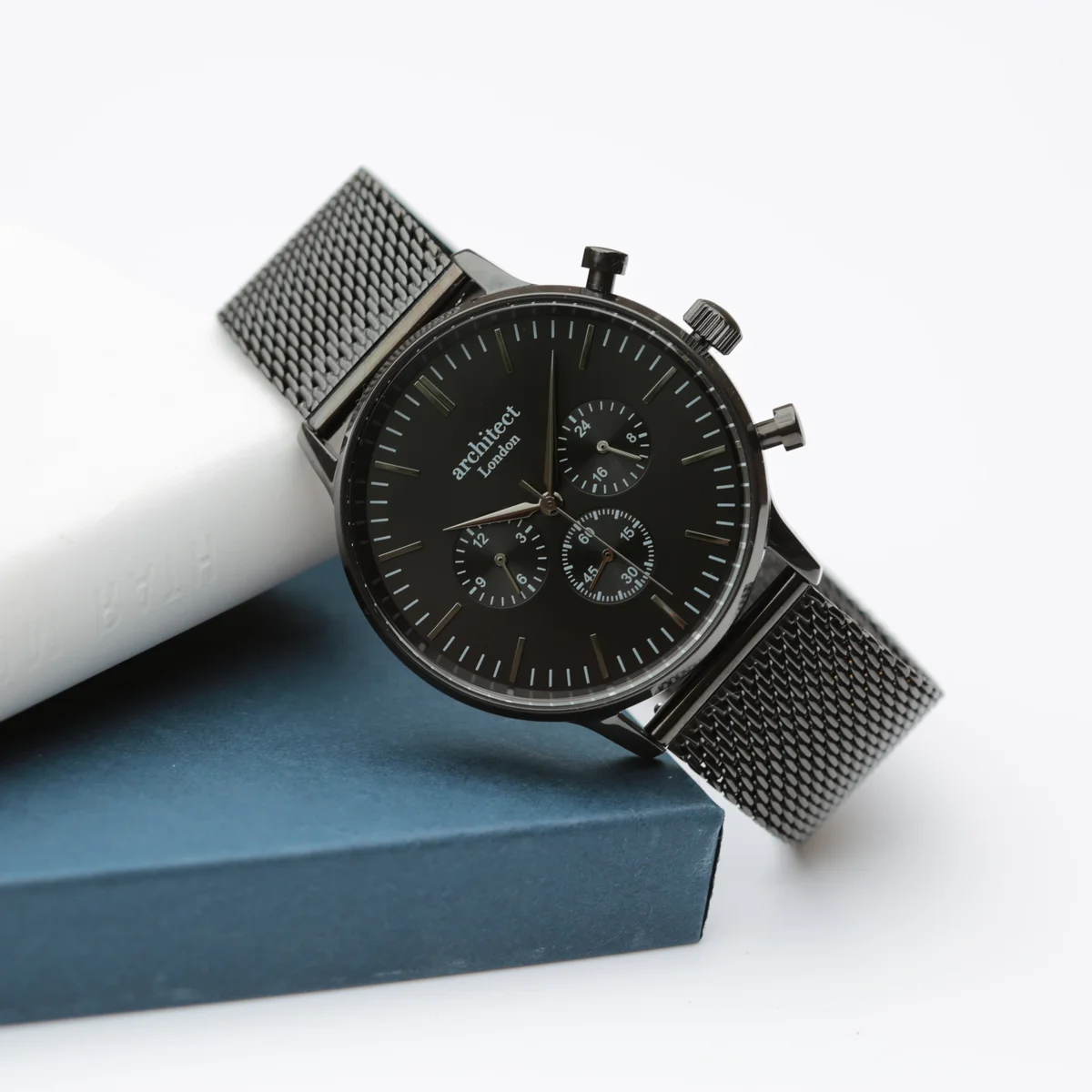 Black Architect Motivator watch with chronograph subdials, black mesh strap, and polished stainless steel case on white background