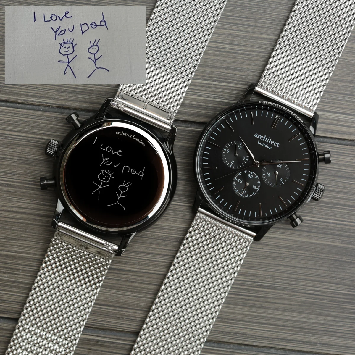 Engraved men's watch with black face, silver Milanese mesh strap, and three chronograph subdials on white background