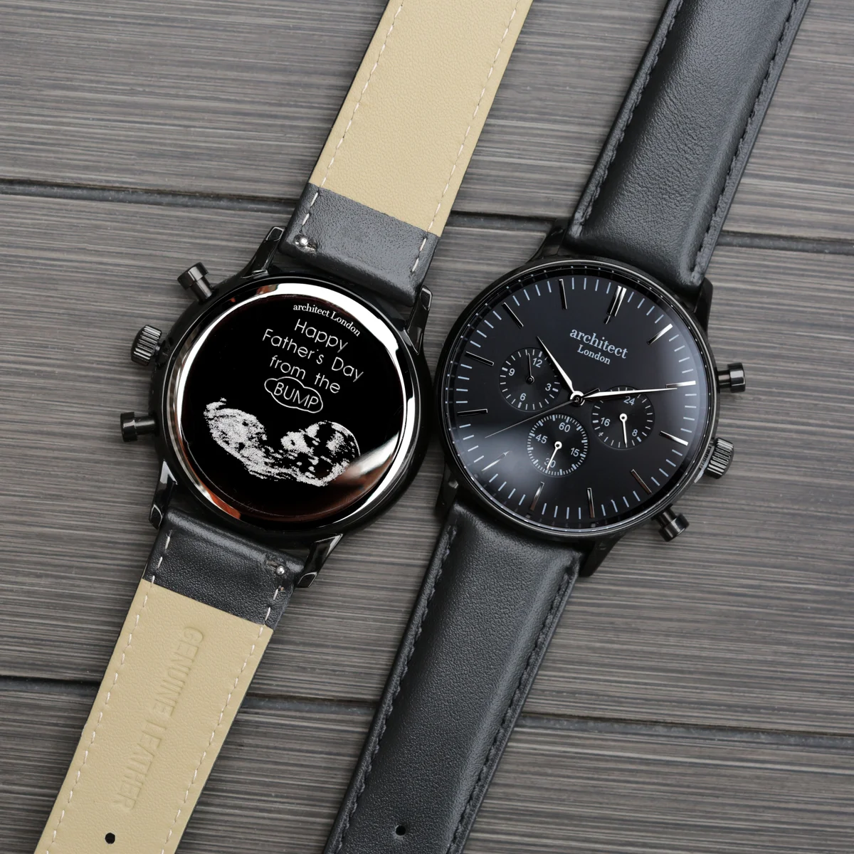Black quartz movement watch with black leather strap and three chronograph subdials on a white background