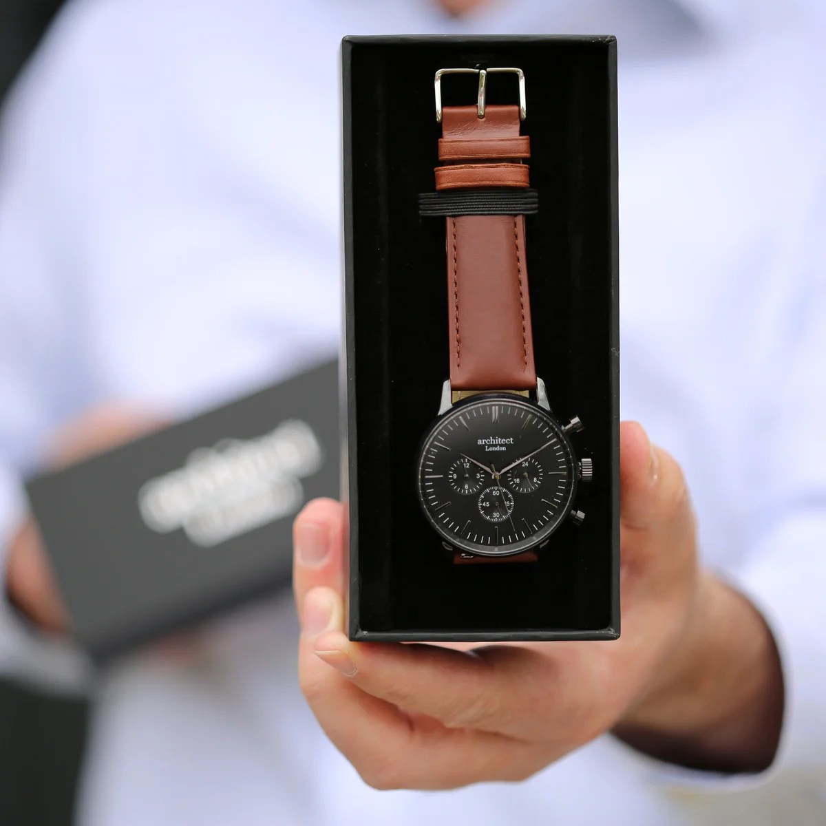 Men's personalised watch with black dial, three chronograph subdials, and dark walnut leather strap on white background