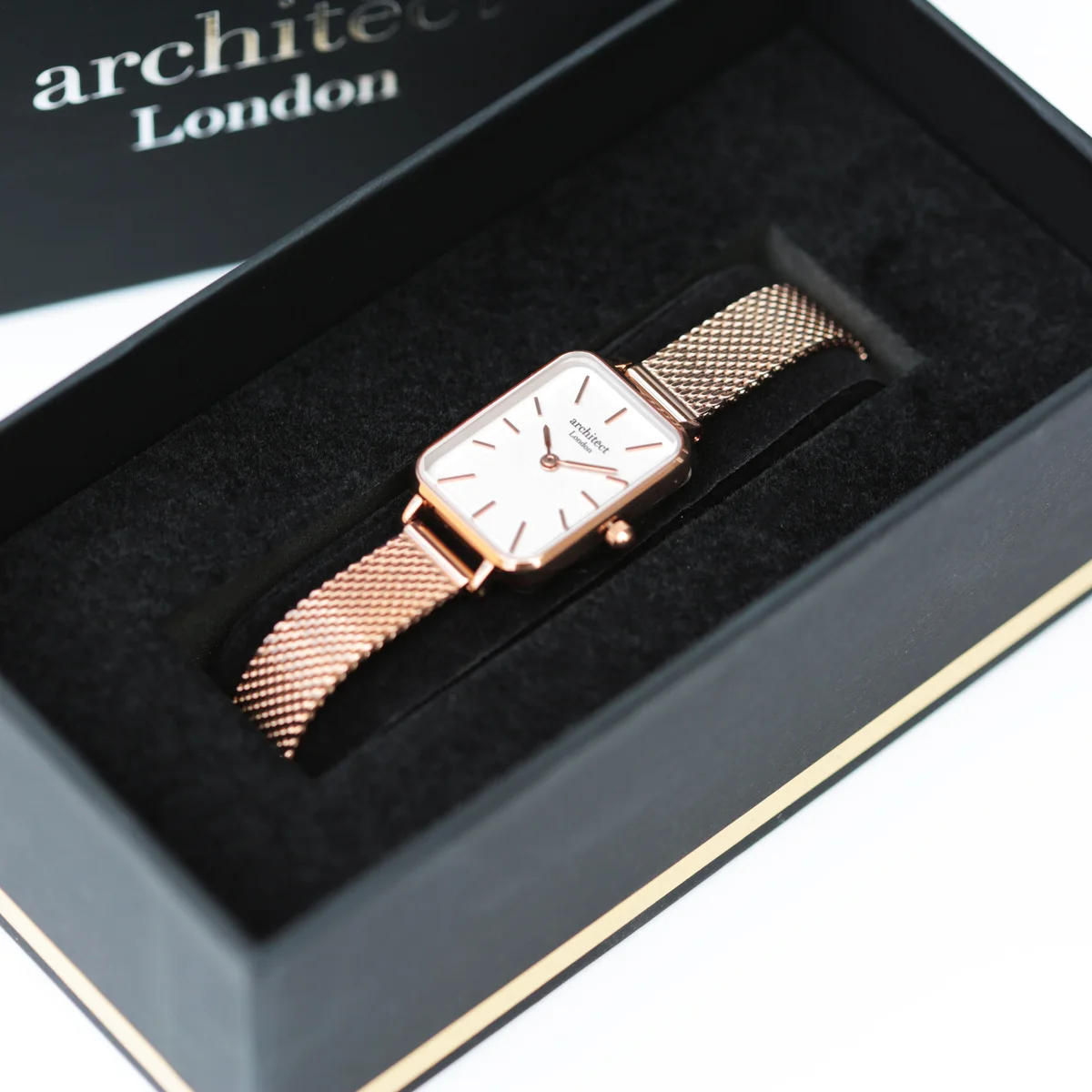 Rose gold mesh strap engraved ladies watch with minimalist dial and stainless steel case on white background