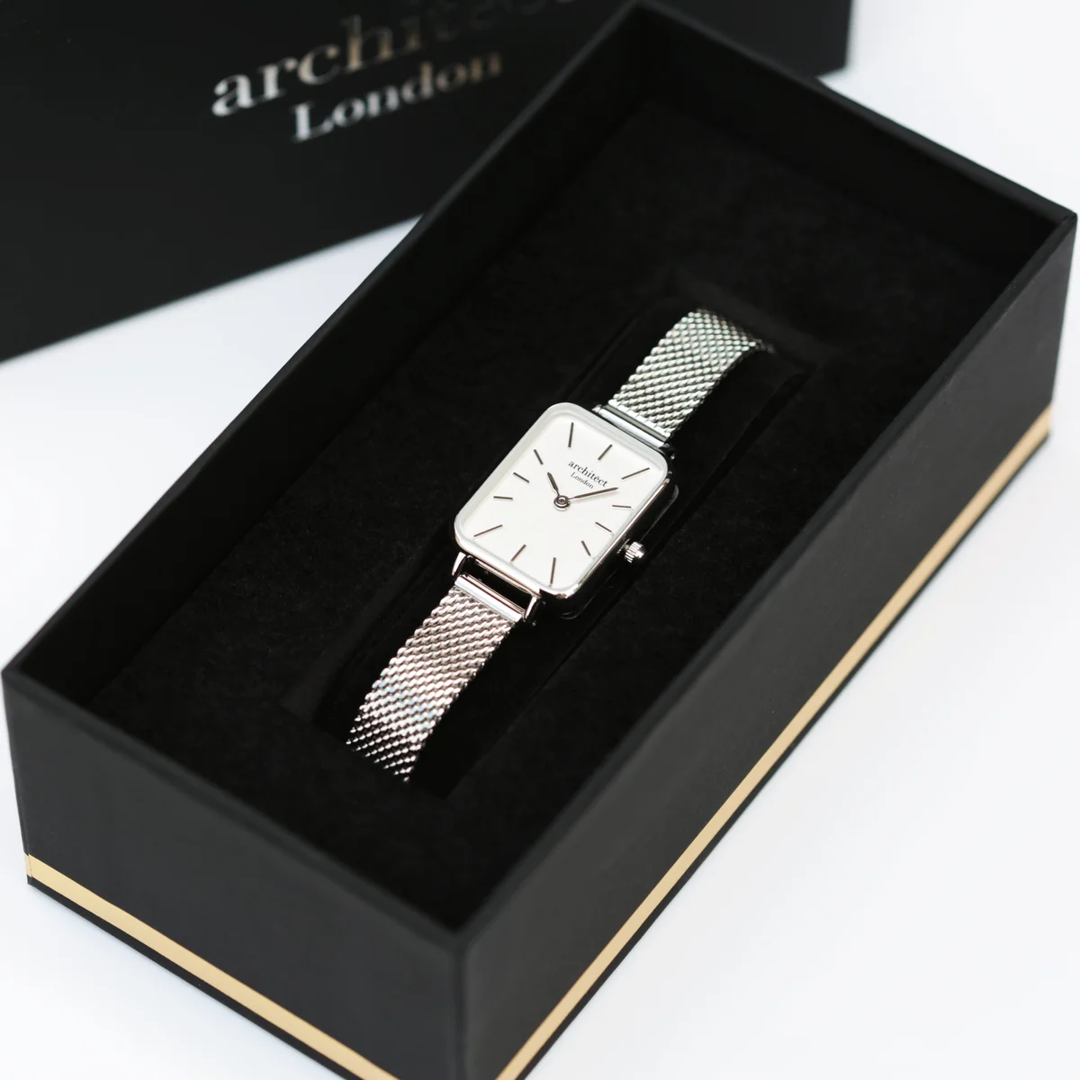 Engraved ladies watch with silver mesh strap and polished stainless steel case on white background