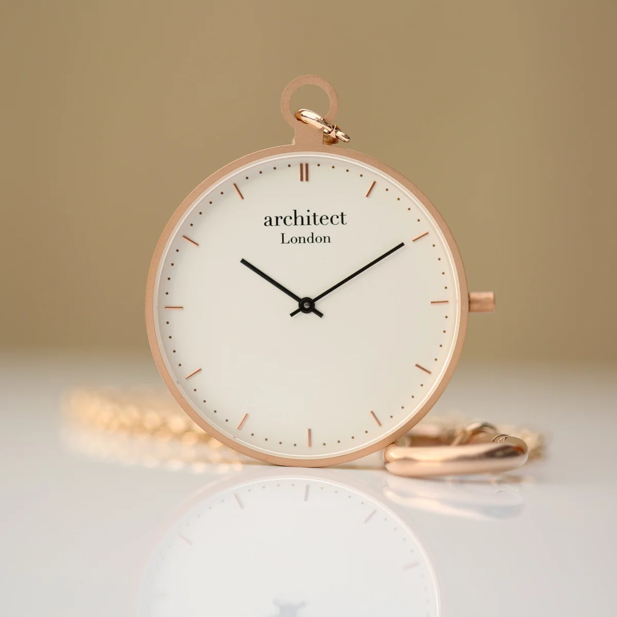 Rose gold pocket watch with modern font engraving, sapphire glass, and brushed stainless steel case on white background