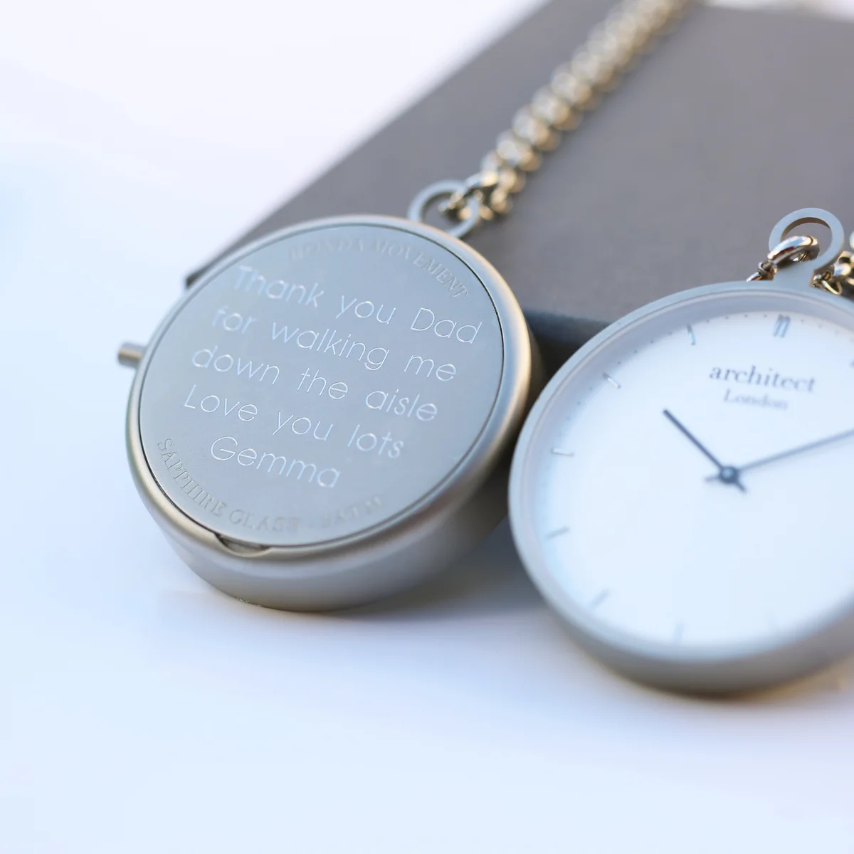 Modern pocket watch in brushed silver stainless steel with sapphire glass and modern font engraving on the back cover