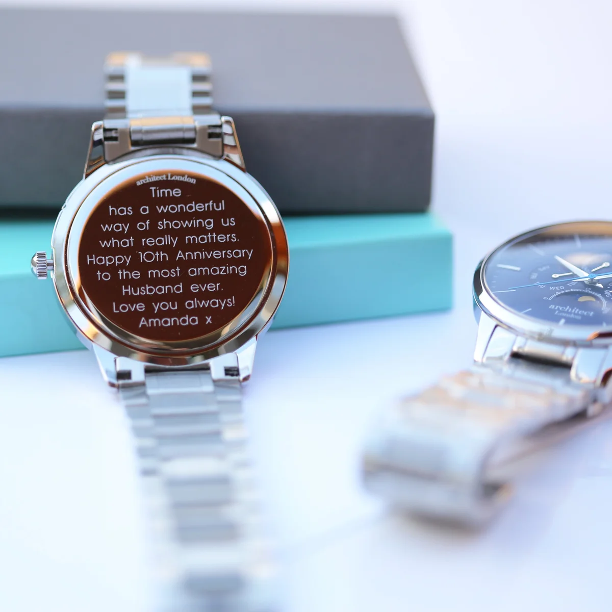 Men's moonphase watch with blue dial, silver stainless steel strap, chronograph subdials, and modern font engraving area