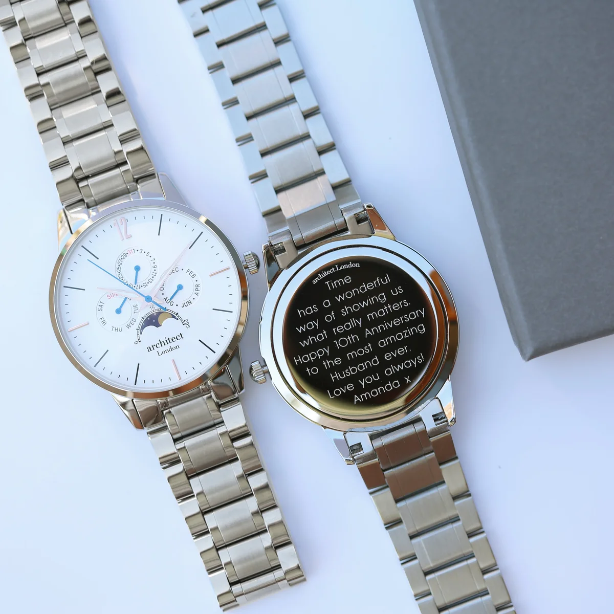 Engraved men's watch with white dial, silver stainless steel strap, moonphase and chronograph subdials on display