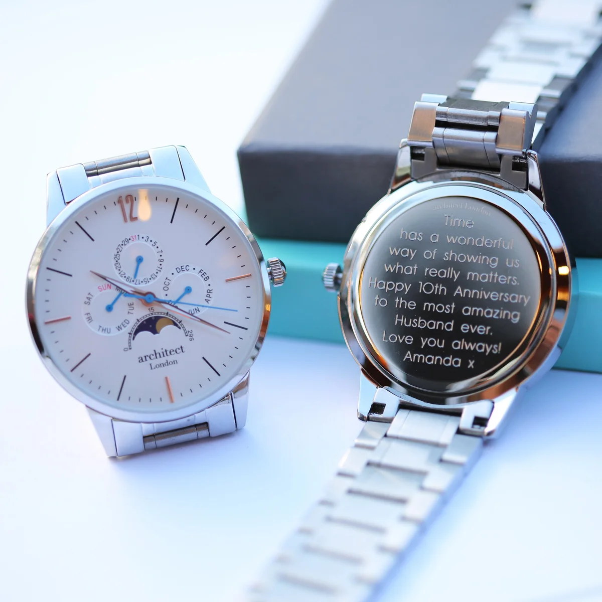 Men's moonphase watch with white dial, silver stainless steel band, chronograph subdials, and modern font engraving area