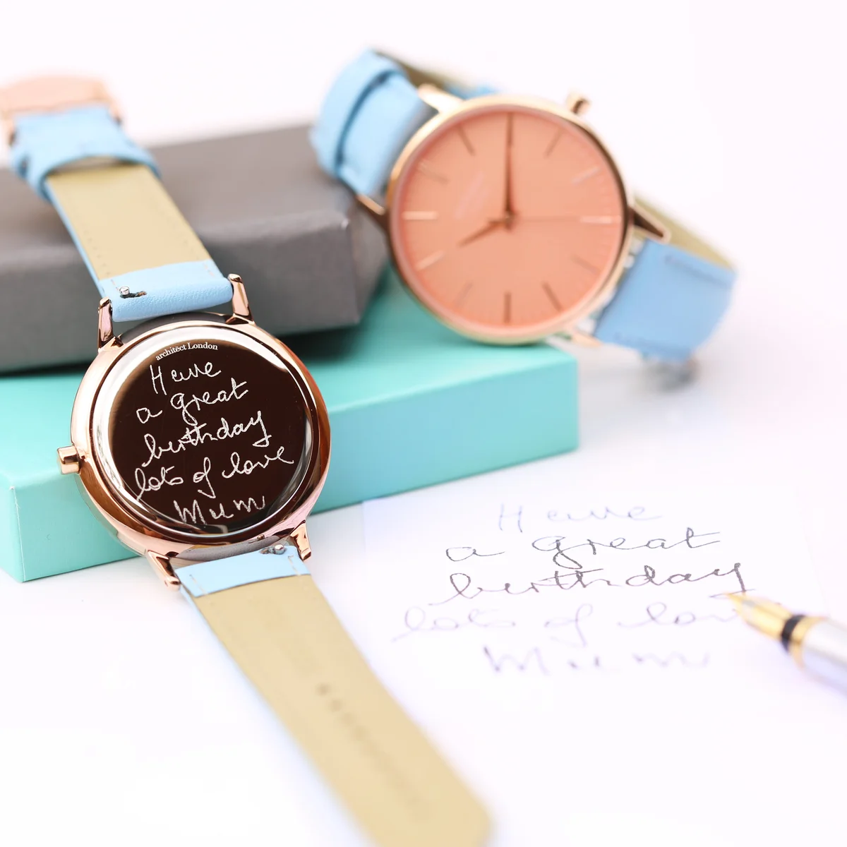 Ladies Architēct Coral stainless steel case watch with coral dial and light blue genuine leather strap on white background