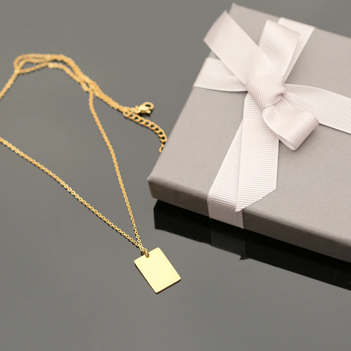 Dazzle necklace in rose gold with delicate handwriting engraving jewellery on a 48cm chain and gift box background