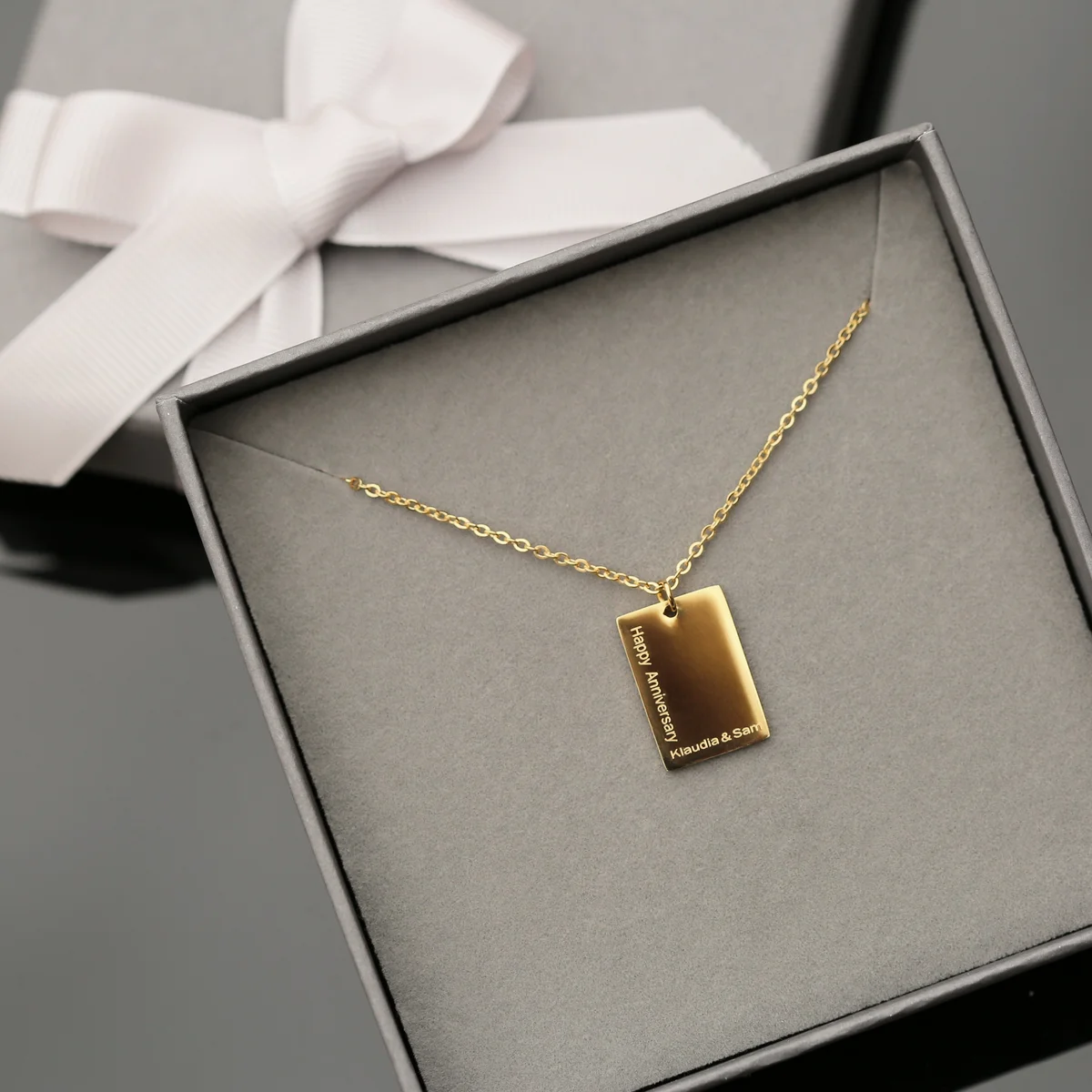 Dazzle personalised necklace in rose gold with modern font engraving on 48cm chain, shown with gift box on white background