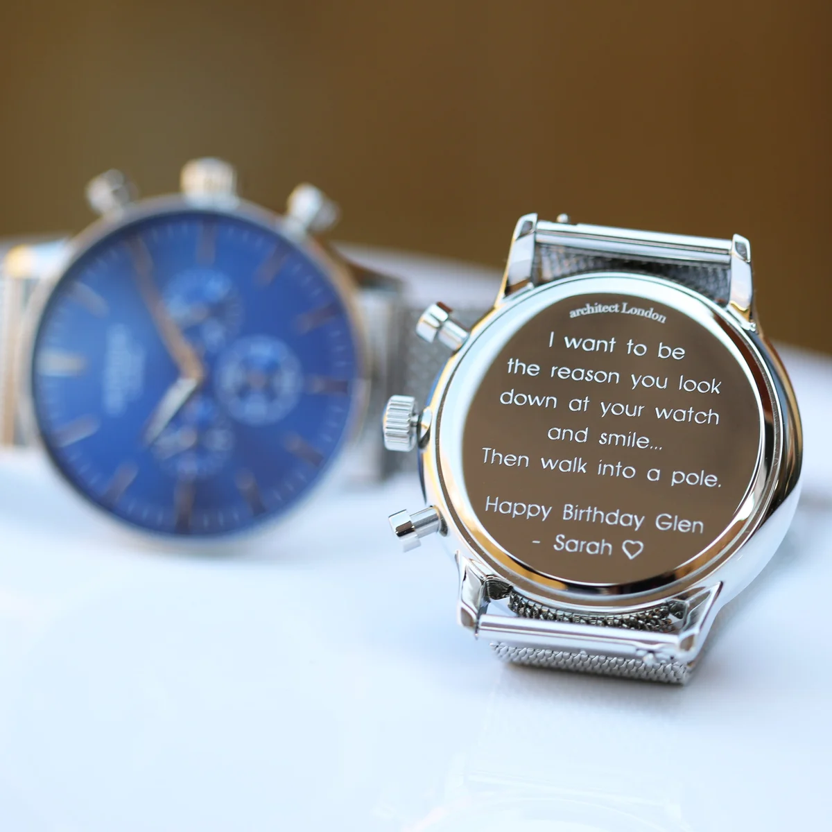 Men's deep-space blue stainless steel watch with silver Milanese mesh strap and three chronograph subdials on white background