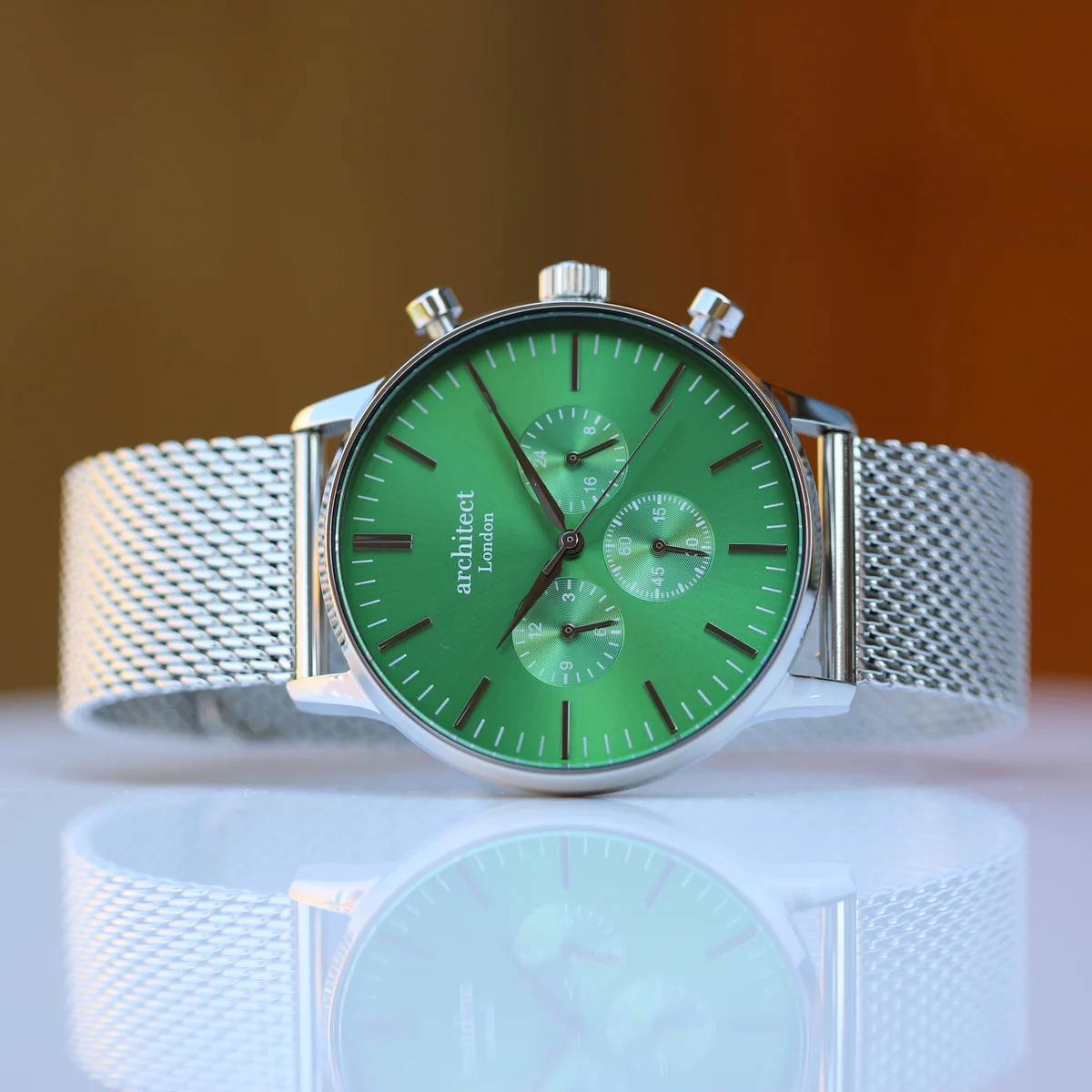 Men’s green dial watch with silver Milanese mesh strap and three chronograph subdials on white background